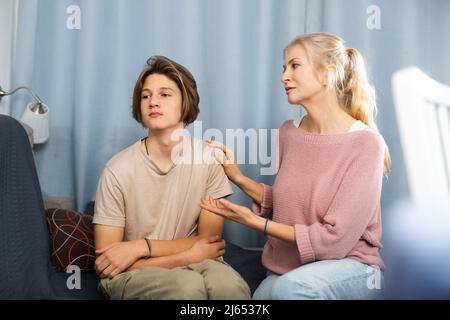 Portrait Of Upset Teen Boy In Sportswear Scolded By Mother At