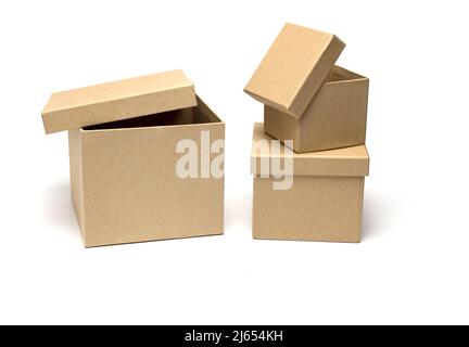 Close up of three cardboard gift boxes of different sizes standing side by side and stacked with partially opened lids on white background Stock Photo