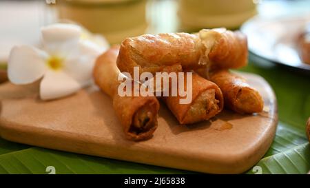 Fried spring rolls on a wooden plate. Asian food concept, Depp fried spring rolls with vegetables. Stock Photo