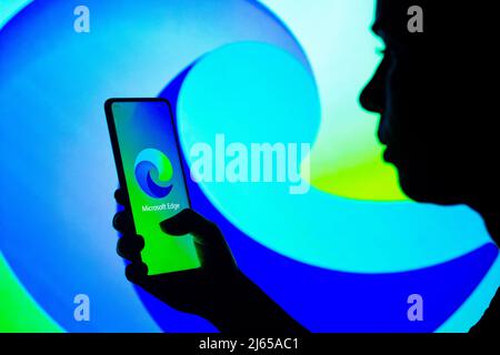 Brazil. 27th Apr, 2022. In this photo illustration, a silhouetted woman holds a smartphone with the Microsoft Edge logo displayed on the screen. (Photo by Rafael Henrique/SOPA Images/Sipa USA) Credit: Sipa USA/Alamy Live News Stock Photo