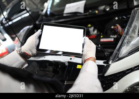 Mechanic worker using tablet for diagnostics of technical condition of vehicle Stock Photo