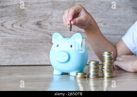 Child woman hand hold pink piggy bank for saving money for education study or investment , Save money concept Stock Photo