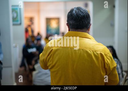 Man addressing people indoors shot from behind Stock Photo