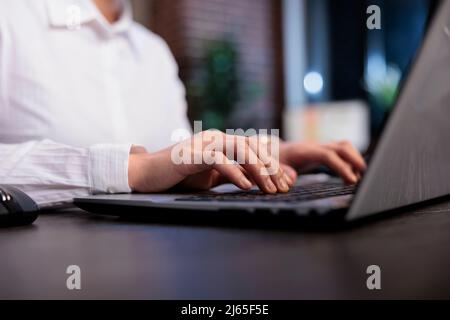 Close up of financial advisor sitting at desk in office workspace while developing marketing strategy on computer. Businesswoman analyzing accounting data and project state. Stock Photo