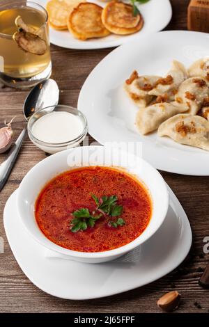 Traditional ukrainian dish vareniki and borscht served with greaves and sour cream. Close up view of traditional Ukrainian food. Stock Photo