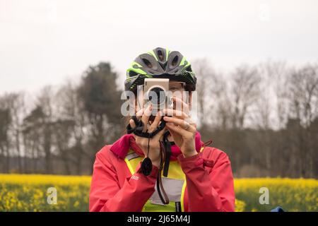 A woman cyclist taking a picture Stock Photo
