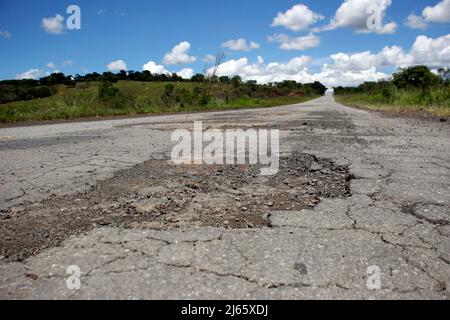 stretch of road with defective and spoiled asphalt, potholes and danger for traffic Stock Photo