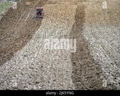 Farm tractor harrowing arable field Stock Photo - Alamy