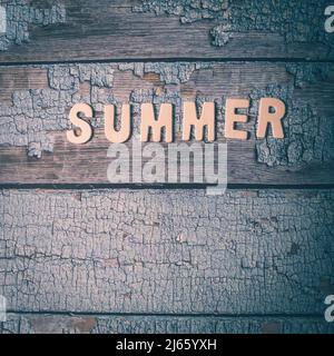 Summer word written on wooden letters text on a textured blue surface Stock Photo