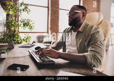 Profile side view portrait of attractive focused guy expert typing remote technical support at workplace workstation indoors Stock Photo