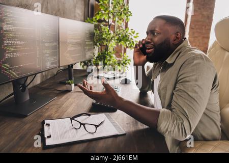 Profile side view portrait of attractive worried guy top manager calling client analyzing project data at workplace workstation indoors Stock Photo