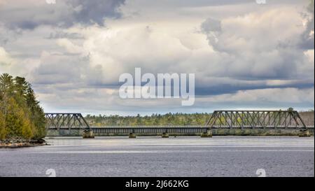 Old abandoned iron truss railway bridge turned into a pedestrian bridge crossing the Ottawa river in spring in Ottawa, Ontario, Canada Stock Photo