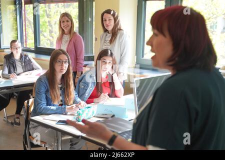 Berlin, Germany. 28th Apr, 2022. Astrid-Sabine Busse (r, SPD), Berlin's Senator for Education, visits a welcome class for students from Ukraine seeking protection at the Hans-Böckler Upper Level Center. In the background you can see the students Alina and Karyna sitting in the front row and behind them the teachers Claudia Bacu and Ekaterina Heuer. Credit: Joerg Carstensen/dpa - ATTENTION: Only for editorial use in connection with the current reporting and only with full mention of the above credit/dpa/Alamy Live News Stock Photo