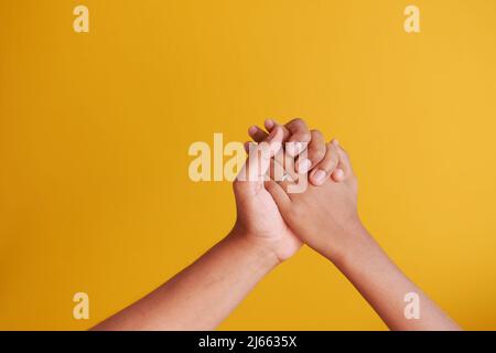 father holding his child boy hand on yellow background  Stock Photo