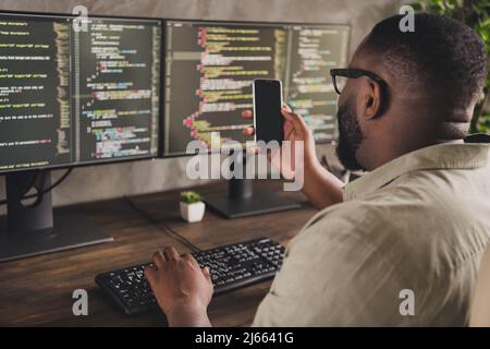 Profile side view portrait of handsome focused experienced guy geek using gadget developing project at workplace workstation indoors Stock Photo