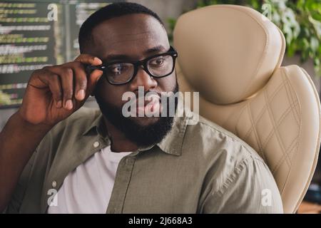 Portrait of attractive successful skilled guy geek expert technician touching specs at workplace workstation indoors Stock Photo