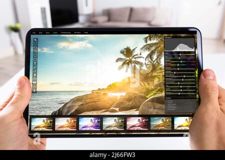 Graphic Designer Editing Photo On Tablet Computer Stock Photo