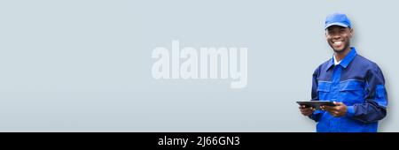 Portrait Of A Happy Young African Electrician Holding Mobile Phone Stock Photo