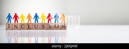 Multi Colored Human Figures Standing On Wooden Cubic Blocks Over Reflective Background Stock Photo