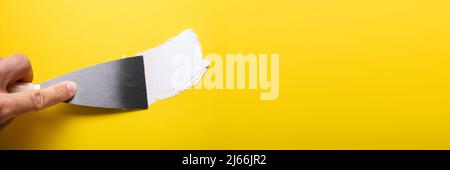 Close-up Of Painter's Hand Puttied Wall Using A Paint Trowel Stock Photo