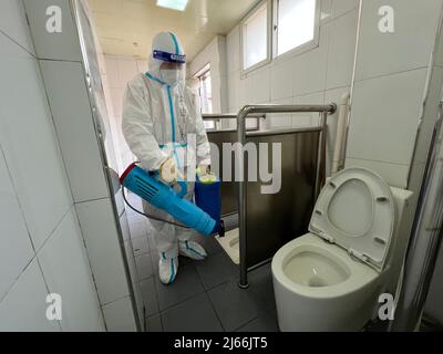 Beijing, China. 24th Apr, 2022. A staff member disinfects a public toilet in Xicheng District of Beijing, capital of China, April 24, 2022. During the latest resurgence of COVID-19 infections in Beijing, people from different walks of life have joined the fight against the coronavirus, working against the clock to offer hearty support. Credit: Jiang Zhen/Xinhua/Alamy Live News Stock Photo