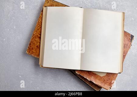 Open vintage book in a super cover on a stack of old dilapidated books Stock Photo