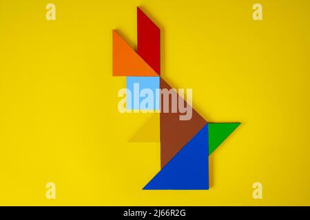 Tangram rabbit, top view of tangram animal rabbit, lay down, isolated on yellow background, colorful tangram puzzle toy concept Stock Photo