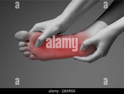 Foot pain. Woman hands holding leg with red point. Black and white. Inflammation, injury, chronic diseases consequences. Health problems concept. High quality photo Stock Photo