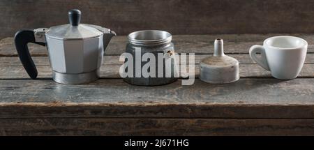 Coffee brewing set. Disassembled Turk and white ceramic coffee cup on wooden texture Stock Photo