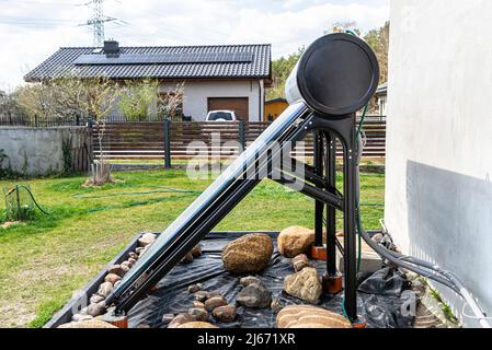 A modern solar pressure collector to heat domestic hot water, standing in front of the house on the lawn. Stock Photo