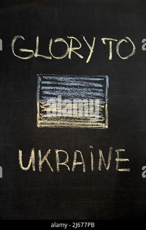 inscription glory to Ukraine on a black board with chalk. ukraine flag drawn with chalk. vertical Stock Photo