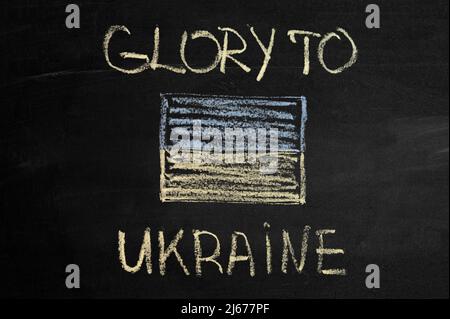 inscription glory to Ukraine on a black board with chalk. ukraine flag drawn with chalk Stock Photo