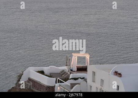 Oia, Greece - May 11, 2021 : A luxury hotel with sunbeds overlooking the Aegean Sea in Oia Santorini Stock Photo