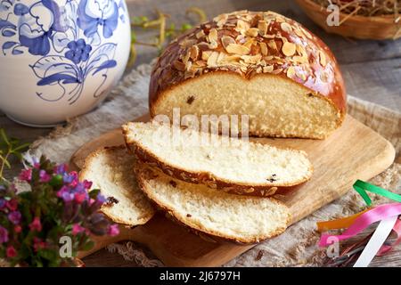 Sweet Easter bread with spring flowers on a table Stock Photo