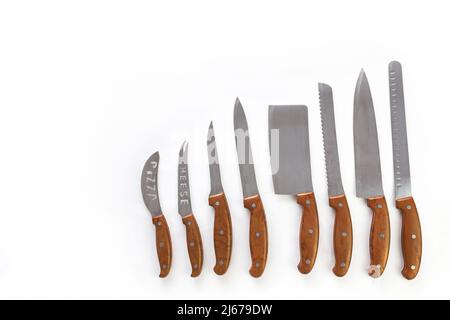 As assortment of kitchen knives flat laid on a neutral background