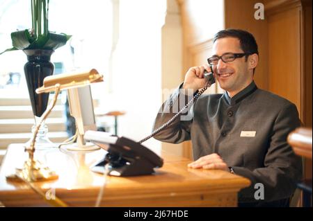 Concierge talking on the phone in a luxury 5 star hotel Stock Photo