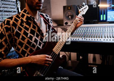 Medium section shot of stylish young Black rock musician playing electric guitar in recording studio Stock Photo