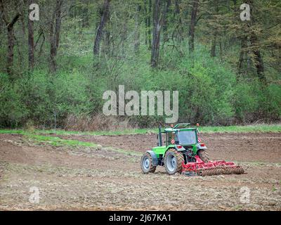Aerial view of farm tractor harrowing arable field Stock Photo - Alamy
