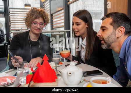 Three amazing business people are showing each other something and discussing it Stock Photo