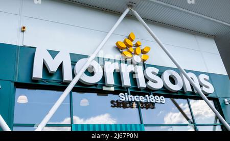 Morrisons name and logo above the entrance to its supermarket in Woking, Surrey, south-east England, viewed from below looking up Stock Photo