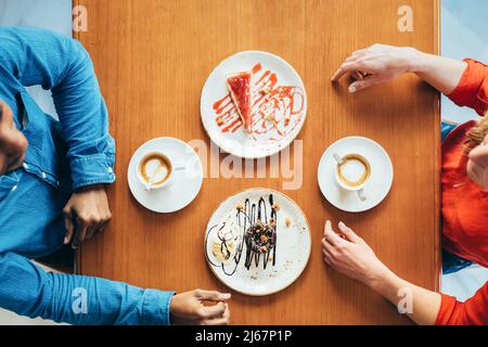 zenithal view of a couple before having a coffee and sweets snack Stock Photo