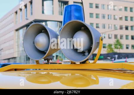 Details of retro police car with a megaphone and flashing blue siren light mounted on top. Loud-hailers on police car Stock Photo