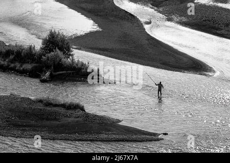 A fly fisherman stands in the middle of the Snake River in Grand Teton National Park. Stock Photo