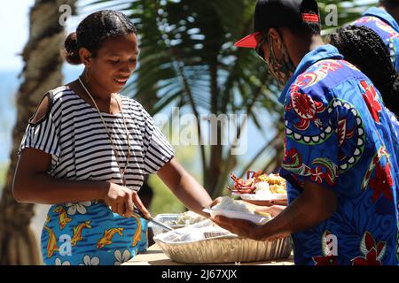 A young Central woman catering to guests at a wedding reception in 2021 at Papa village, Papua New Guinea. Stock Photo