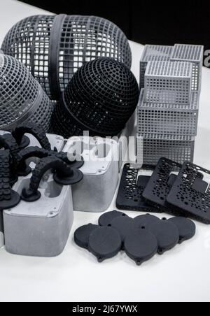 Many different models printed on 3D printer. Gray and black objects printed Stock Photo