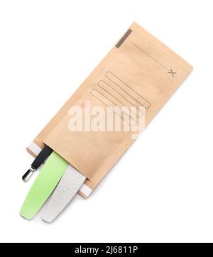 Paper bag with clean manicure tools on white background Stock Photo