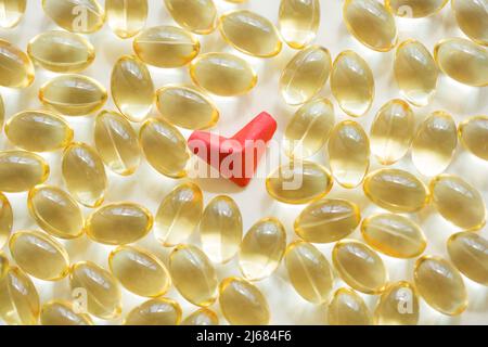 Red heart-shaped origami and soft capsule softgel on white background - stock photo Stock Photo