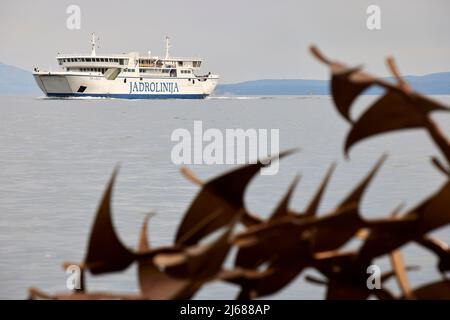 The city of Split in Croatia in the region of Dalmatia, the waterfront harbour ferry framed with Scultura di gabbiani in volo Stock Photo