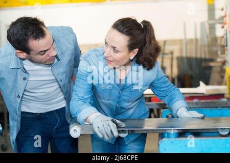 female working at a metal factory with colleague Stock Photo