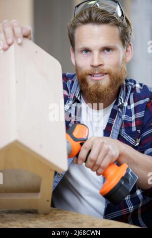 men in home clothes work with a screwdriver Stock Photo